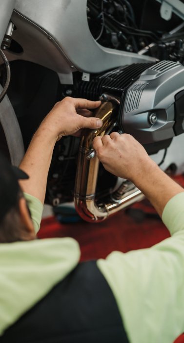 Repairman repair motorcycle, maintenance in garage. Mechanic fixing bike in a modern shop